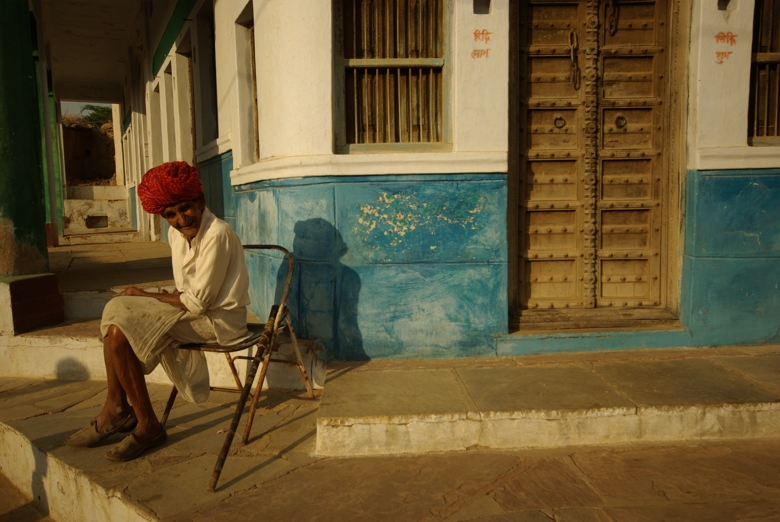 Indian guy sitting on a chair on street