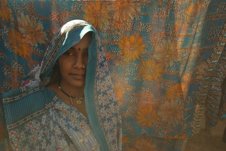 Indian woman in front of fabric