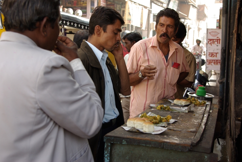 Men busy eating on the street
