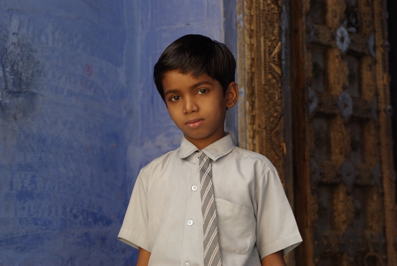 School boy in front of blue wall