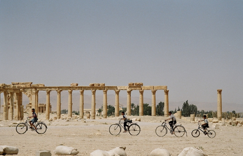 Children riding bike in ancient city ruins